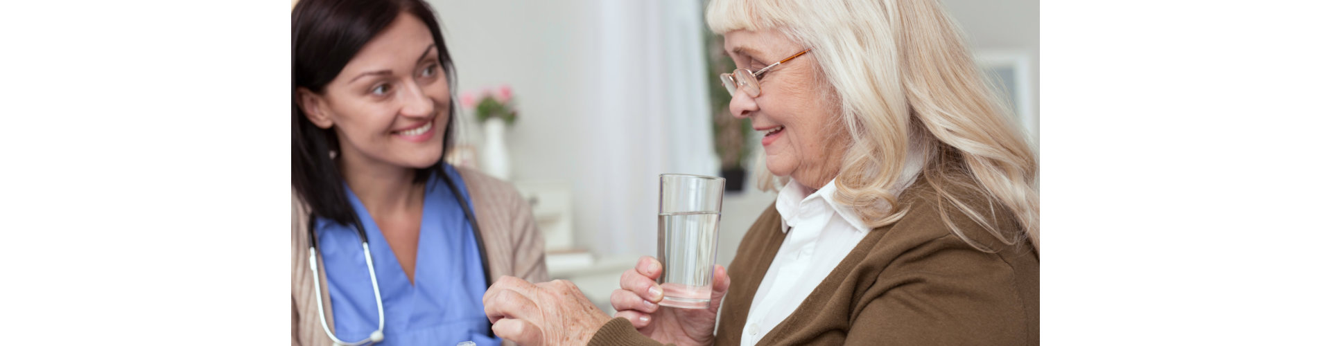 female nurse giving medicine to senior woman